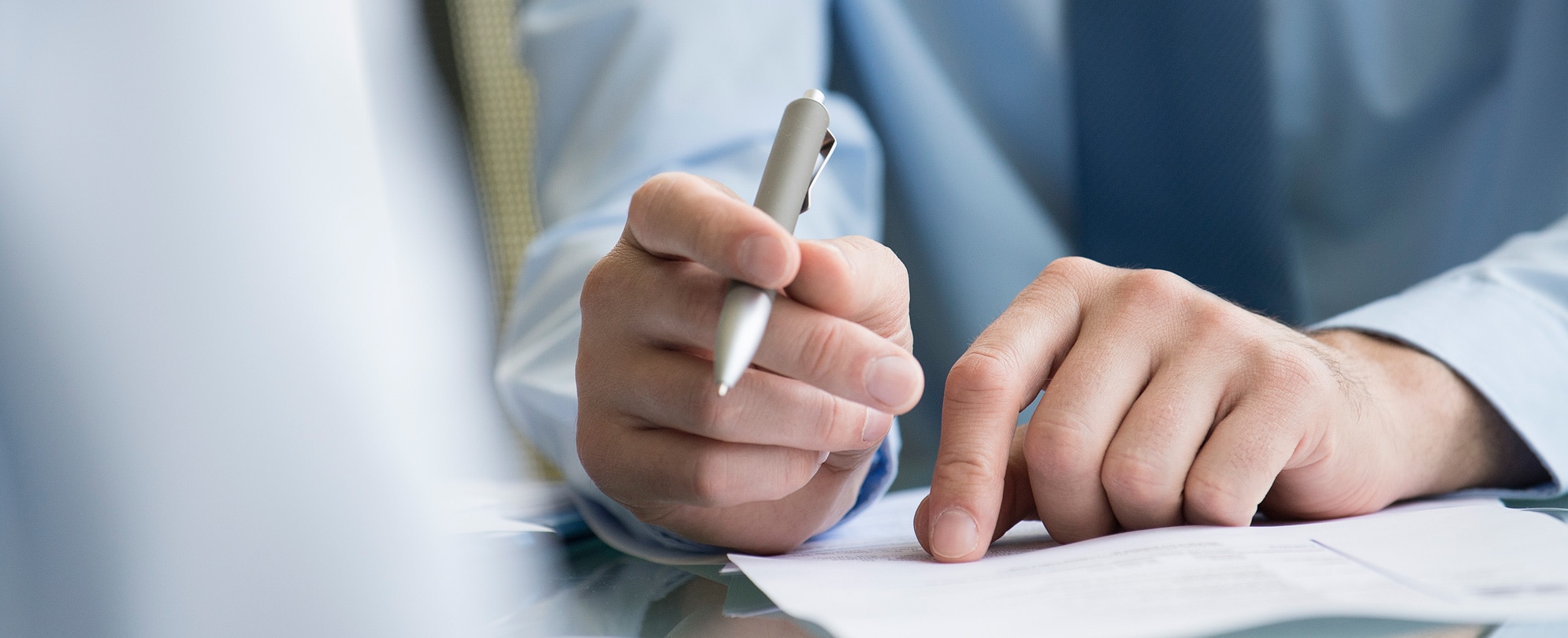Close up of a timeshare attorneys hand, holding a pen, and reviewing an important timeshare document 