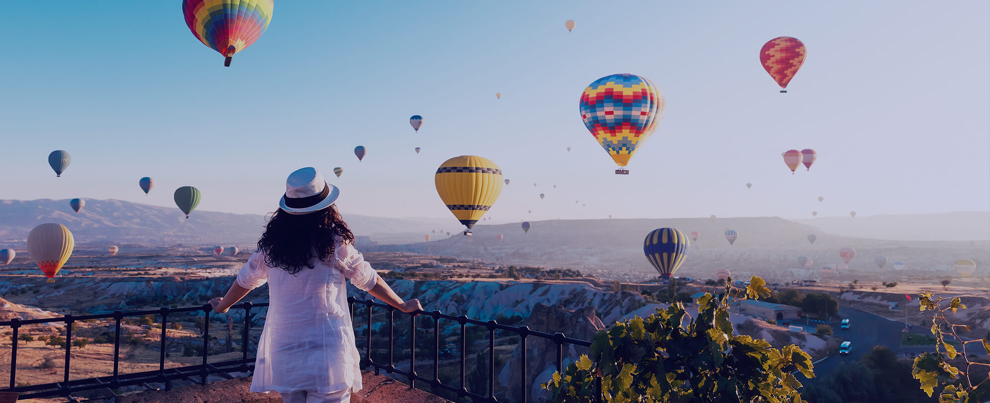 Woman in hat looking at hot airballoons