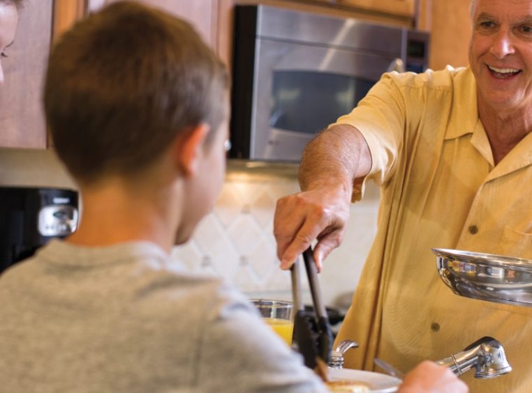Senior man plating his grandson's dinner 