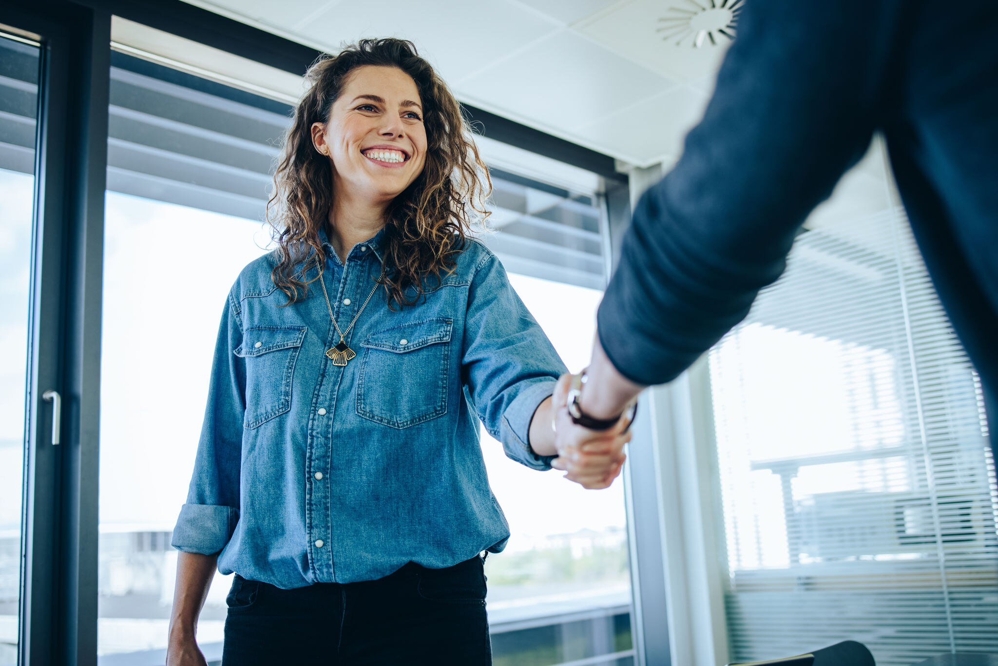 Recruitment manager shaking hand with male candidate