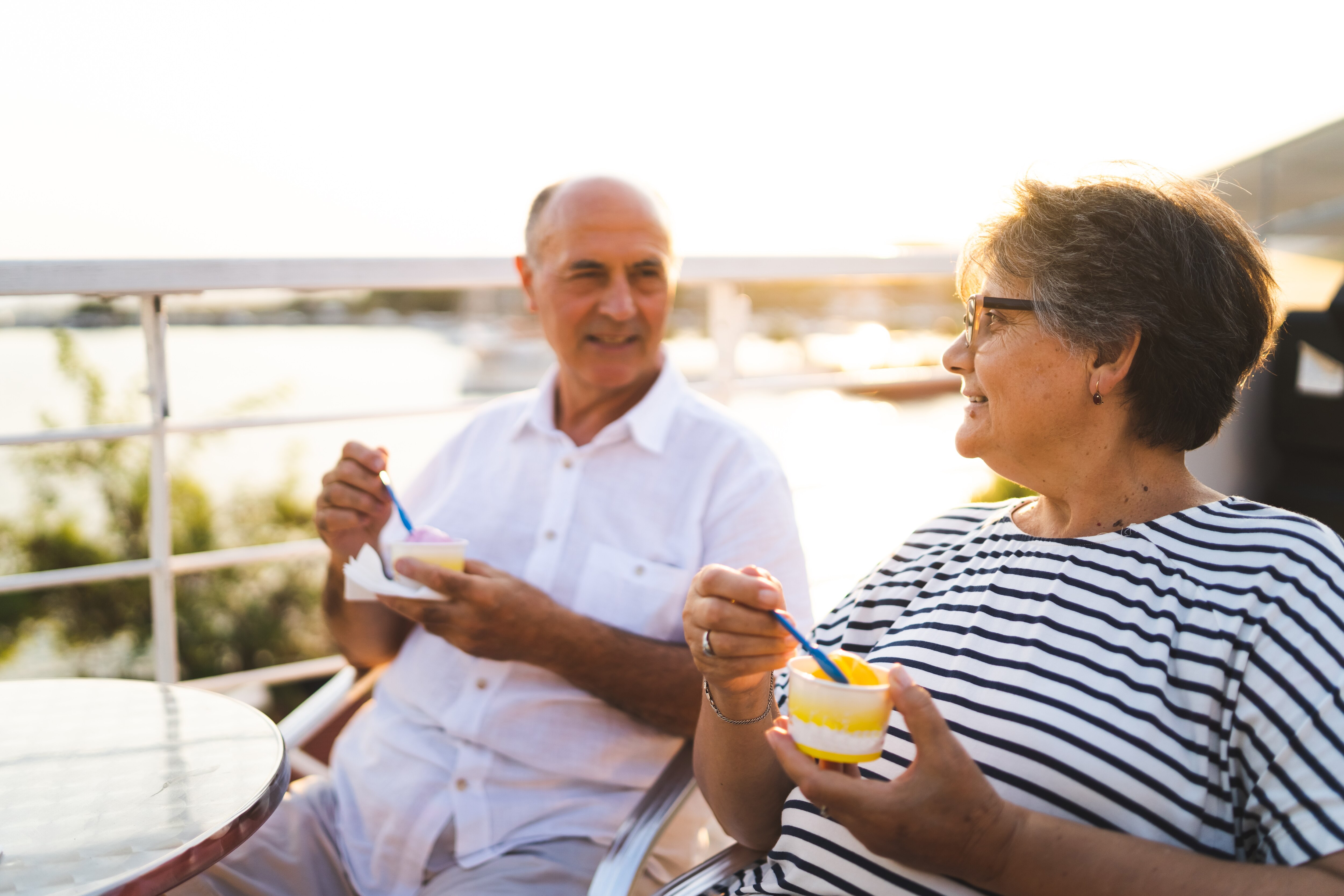 Senior couple is eating ice cream in seaside café